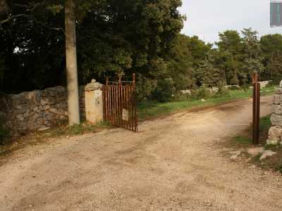 Dopo circa un chilometro il viottolo ci porta davanti a un cancello arrugginito: lo apriamo